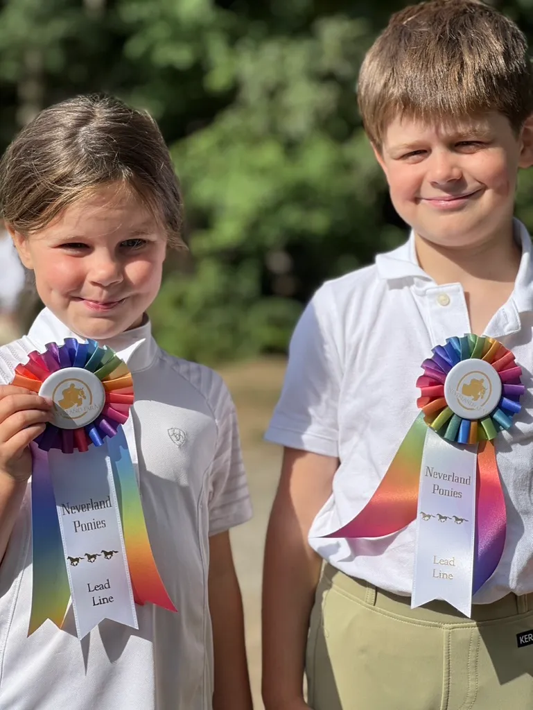 Athletes proudly showing their ribbons after a home horse show